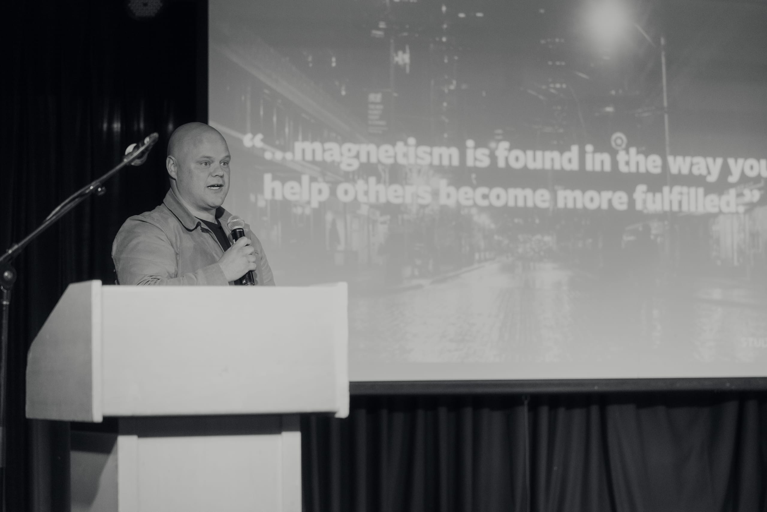 Matt Ramage presenting on stage about brand presence and impostor syndrome