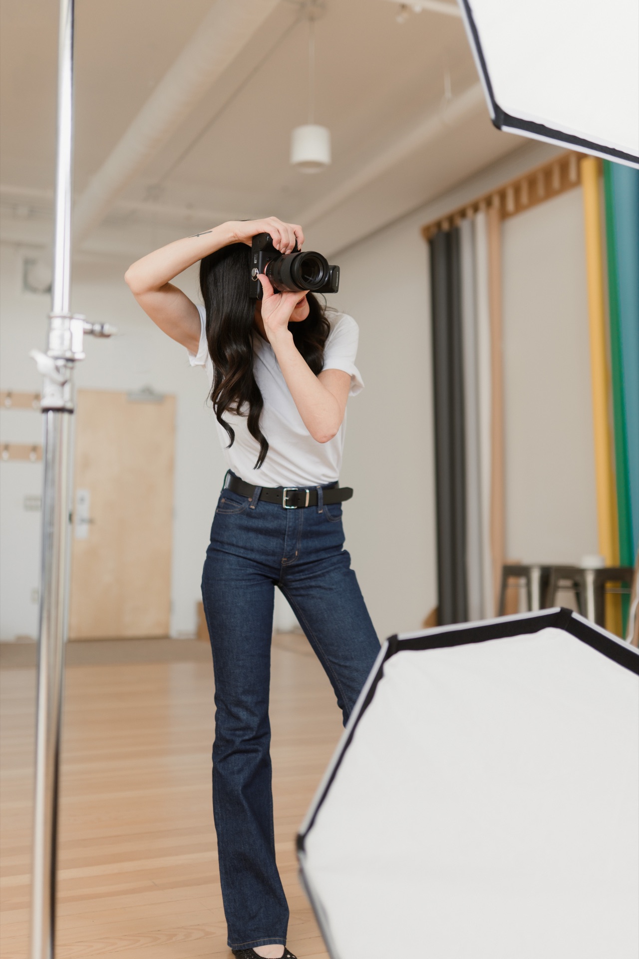 A photographer working with studio lighting and reflectors