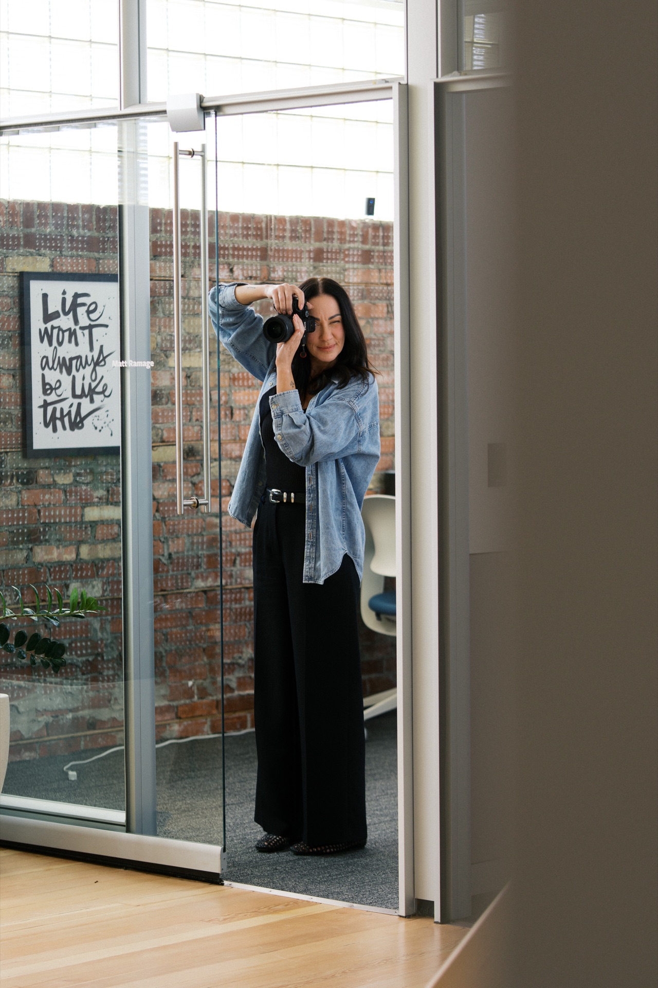 A photographer taking a photo beside the studio’s glass doors