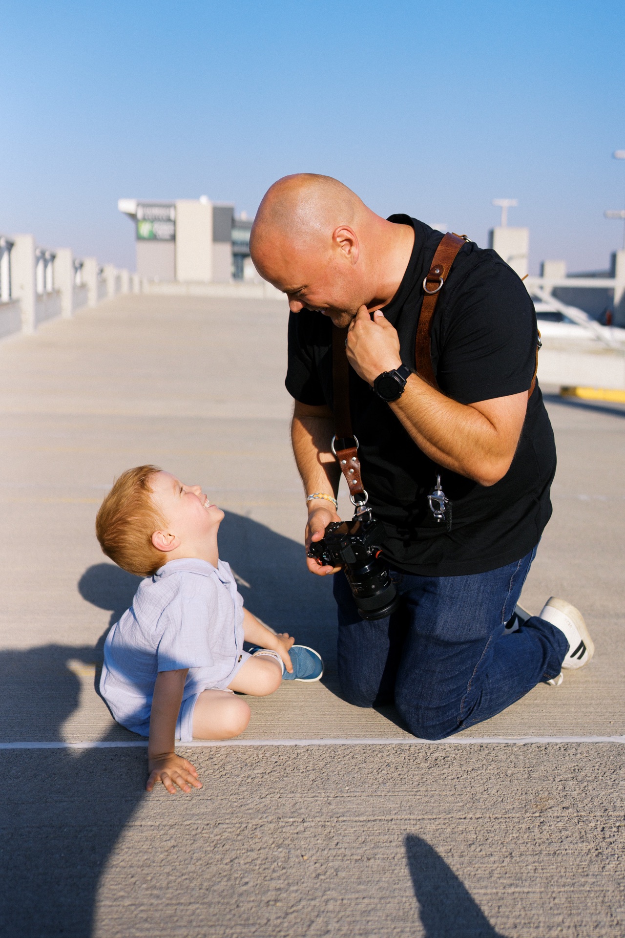 A photographer and child sharing a laugh during an outdoor session