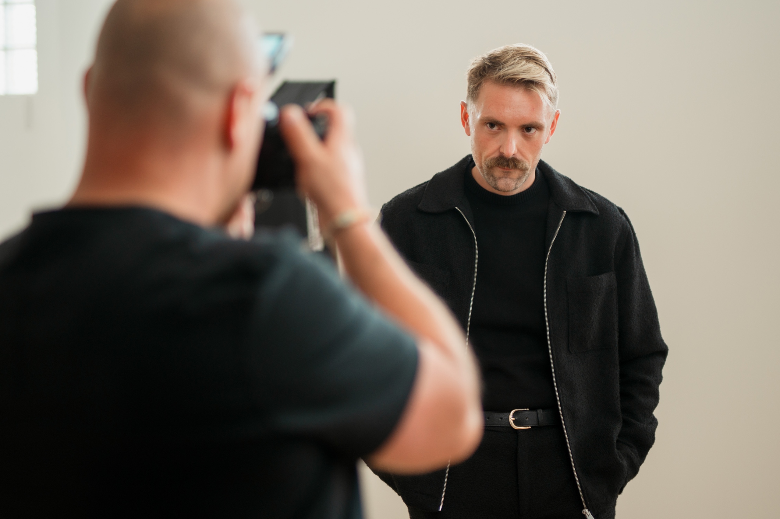 A photographer framing Jordon during the studio portrait session.