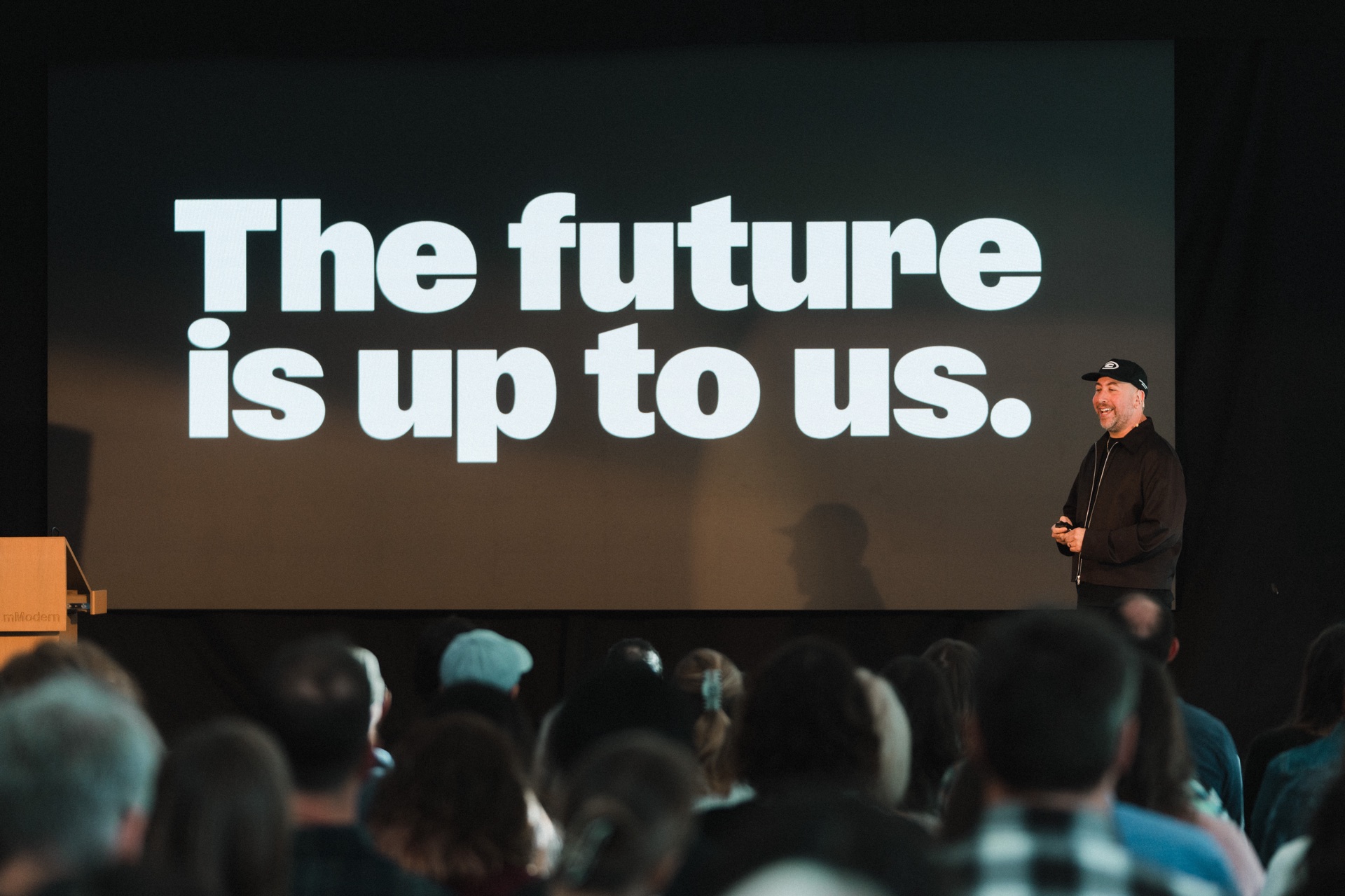 A speaker presents to the audience beneath a slide reading The future is up to us at Memo Creative Festival.