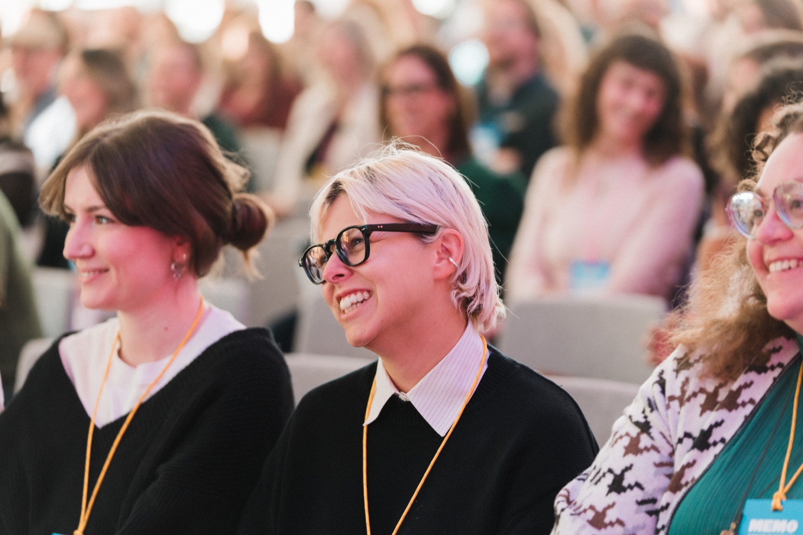 Audience members smiling during a presentation at Memo Creative Festival in Saskatoon.